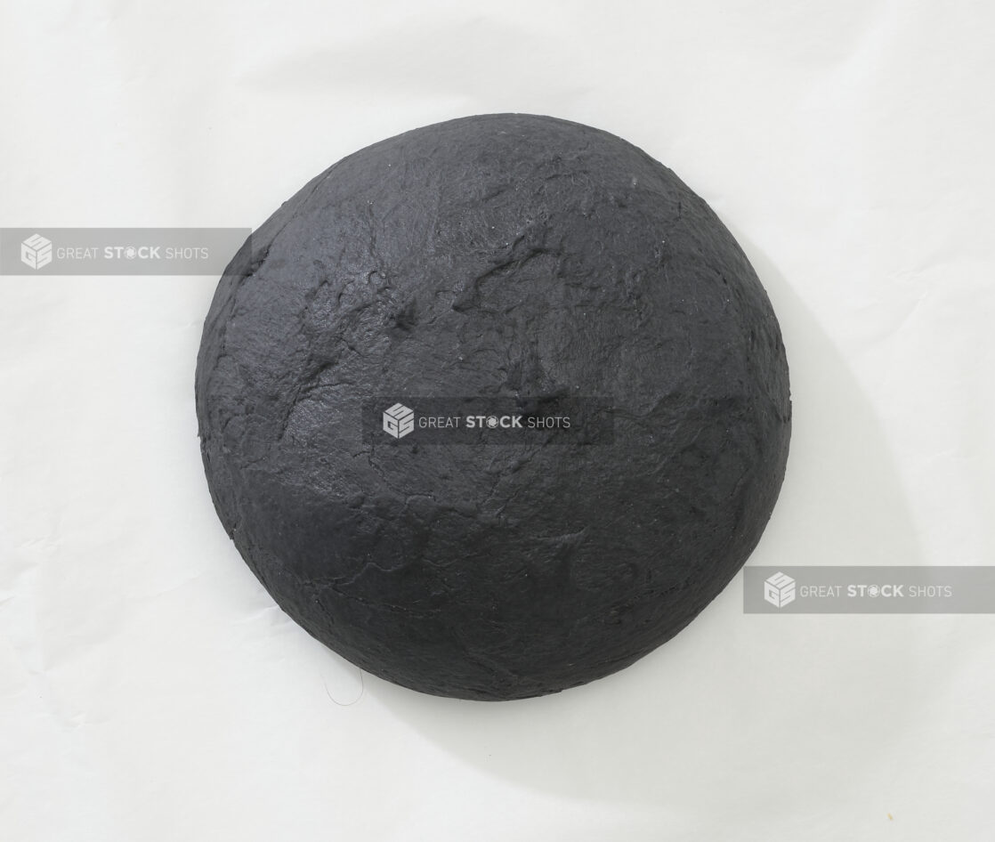 Overhead View of a Charcoal-Infused Black Pizza Dough Ball, on a White Background for Isolation