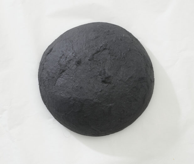 Overhead View of a Charcoal-Infused Black Pizza Dough Ball, on a White Background for Isolation