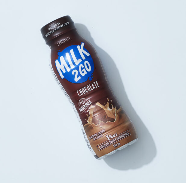 A plastic bottle of chocolate milk on a light blue background