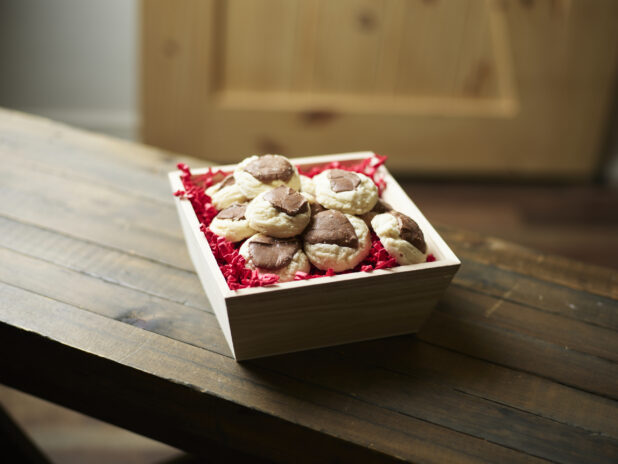 Valentine's Day gift box with cookies on dark wooden table