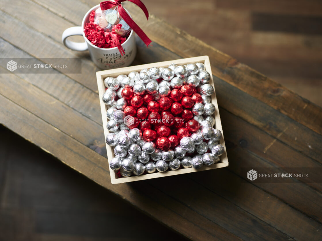 A Valentine's Day gift box with red and silver chocolate foil balls and accompanying mug