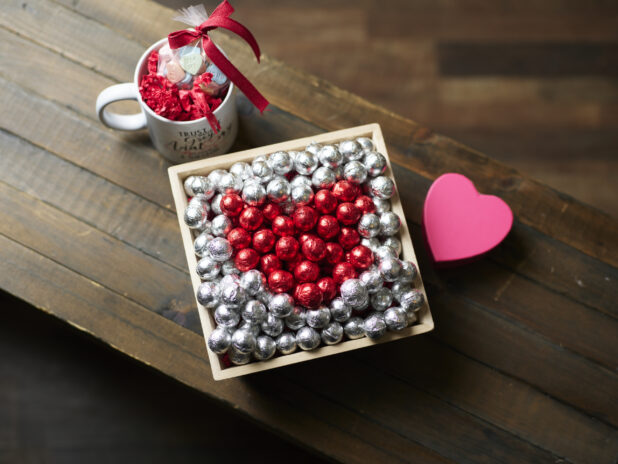 A Valentine’s Day gift box with red and silver chocolate foil balls and accompanying mug