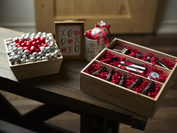 Wooden gift boxes for Valentine's Day with chocolates, essential oils and an accompanying mug