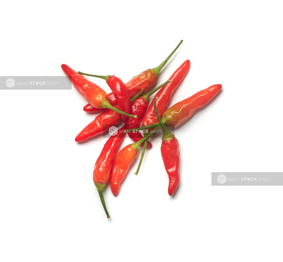 Red chili peppers, thai chilis, with the stems on, on a white background