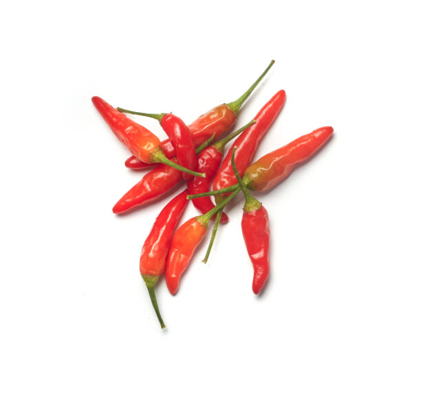 Red chili peppers, thai chilis, with the stems on, on a white background