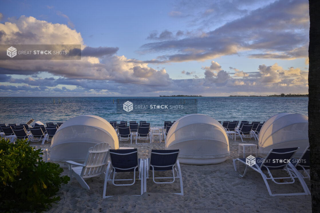 Rows of Beach Chairs and Domed Tents Facing Turquoise Waters on a White Sandy Beach in a Resort in Nassau, Bahamas