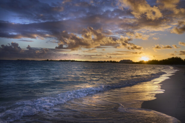 Landscape View of a Sandy Tropical Beach Shoreline and Waves at Sunset or Sunrise in Nassau, Bahamas