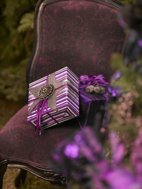 Close Up of a Stack of Purple Gift Boxes on an Antique Dining Chair in an Outdoor Setting