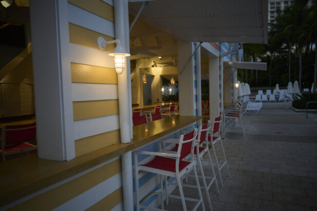 Close-Up of a Row of Poolside Bar Stools for a Painted Wood Bar Spot Lit Up at Night in a Resort in Nassau, Bahamas