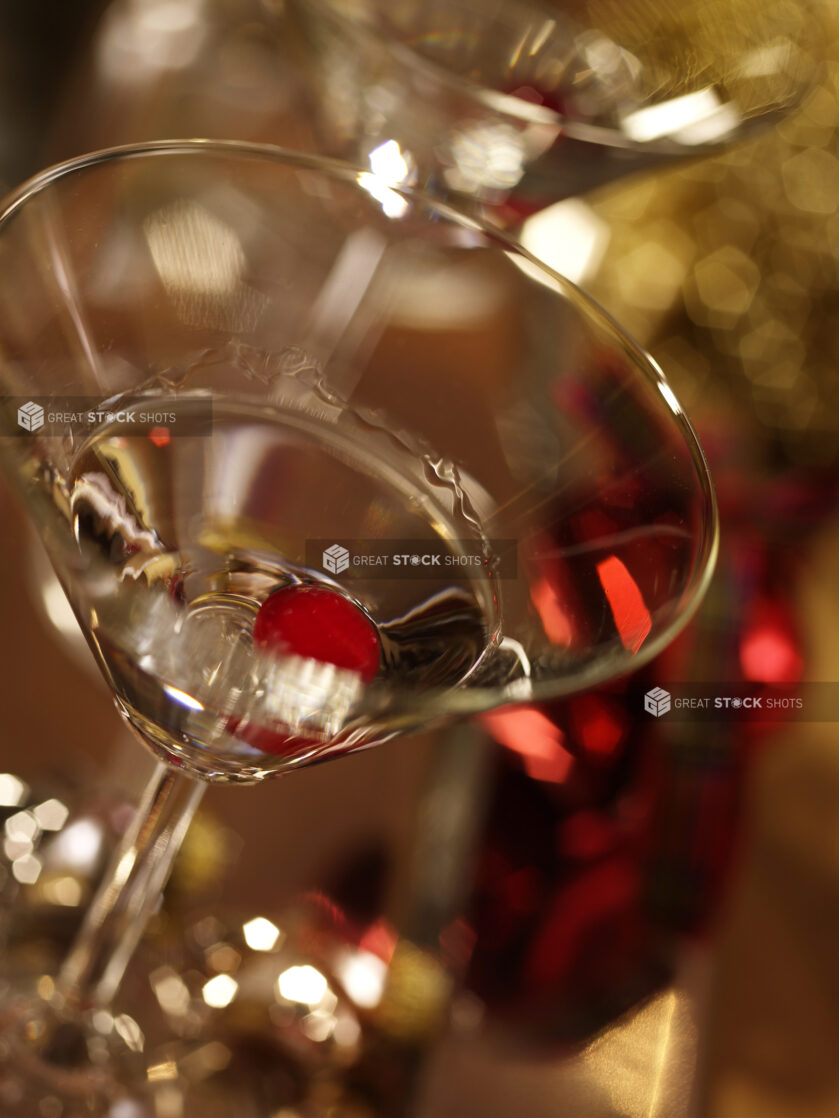 Close Up of Vodka and a Maraschino Cherry in a Martini Glass with a Heavy Bokeh Effect in the Background in an Indoor Setting