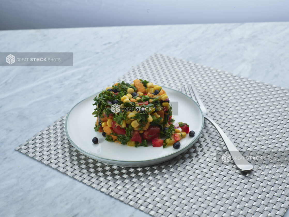 Brightly coloured Southwestern roasted sweet potato dish on white ceramic side plate, close-up