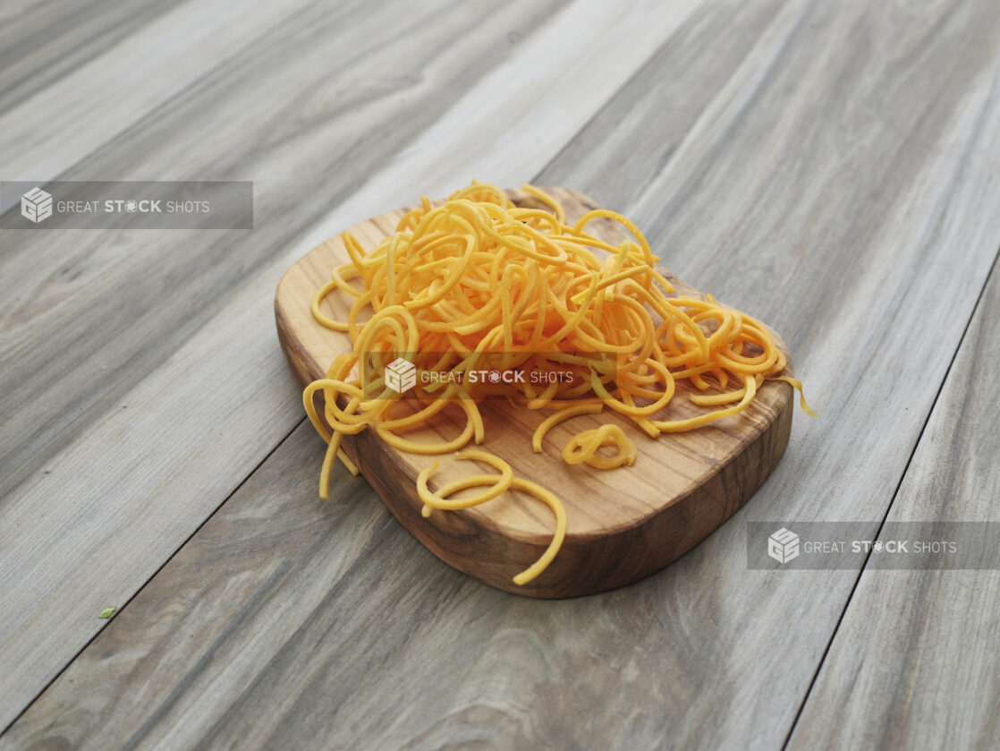 Spiralized butternut squash on a small wooden board, close-up