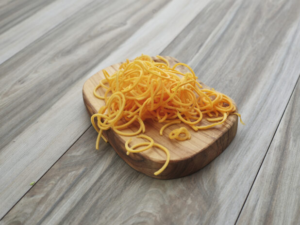 Spiralized butternut squash on a small wooden board, close-up