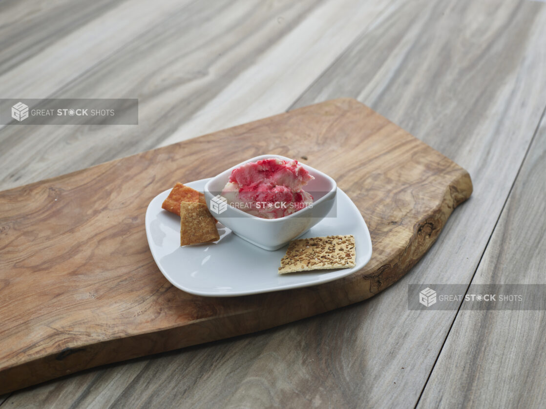 Provolone and chianti cheddar spread in a plated white ramekin on a natural wood board