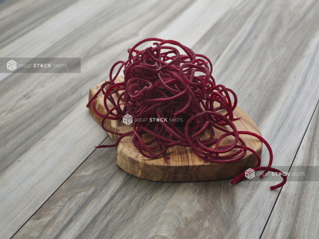 Spiralized beets on a small wooden board, close-up