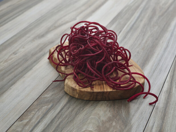 Spiralized beets on a small wooden board, close-up