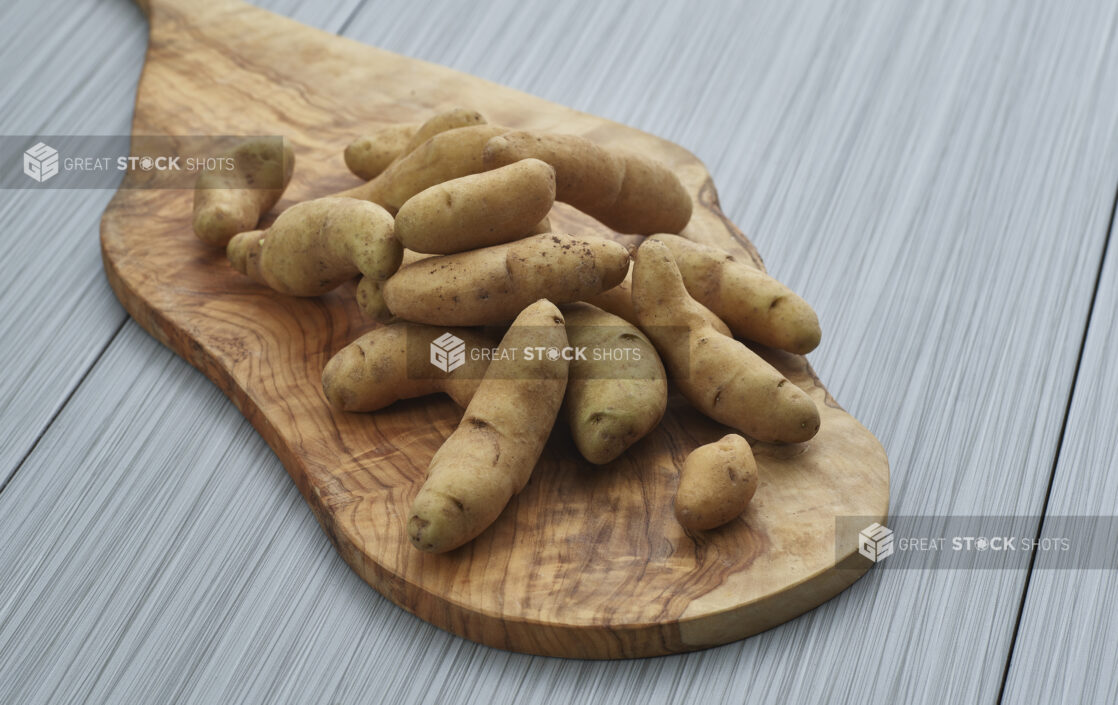 Fingerling potatoes piled on a wooden paddle, close-up