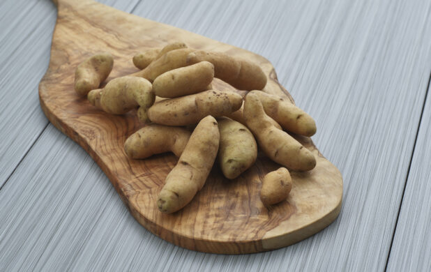 Fingerling potatoes piled on a wooden paddle, close-up