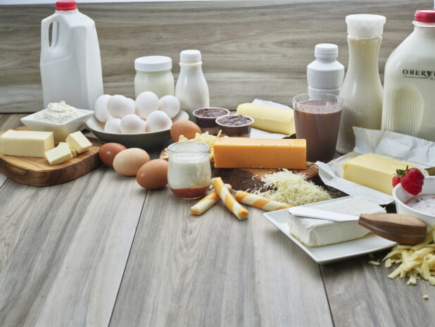 Spread of eggs and dairy products on grey wood background