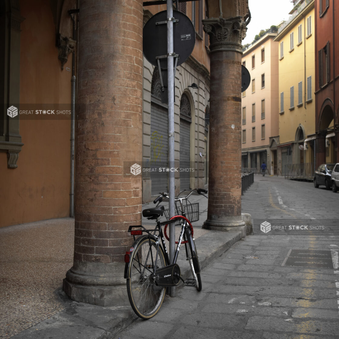 A Bicycle Parked Along a Cobblestone Street in Bologna, Italy