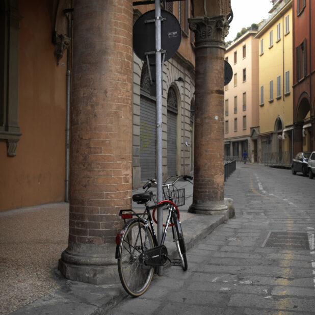 A Bicycle Parked Along a Cobblestone Street in Bologna, Italy