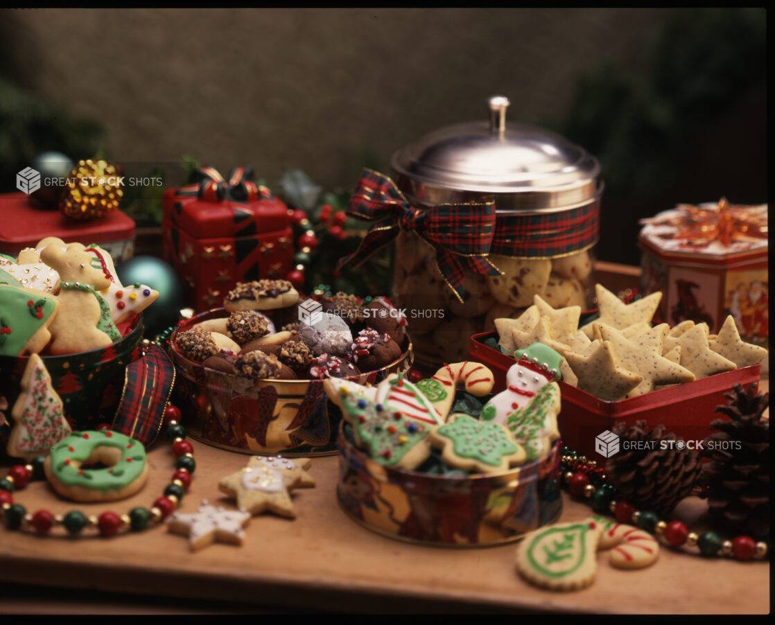 Holiday and Christmas Themed Cookies in Tins Surrounded by Christmas Decorations in a Cookie Exchange Setting Indoors