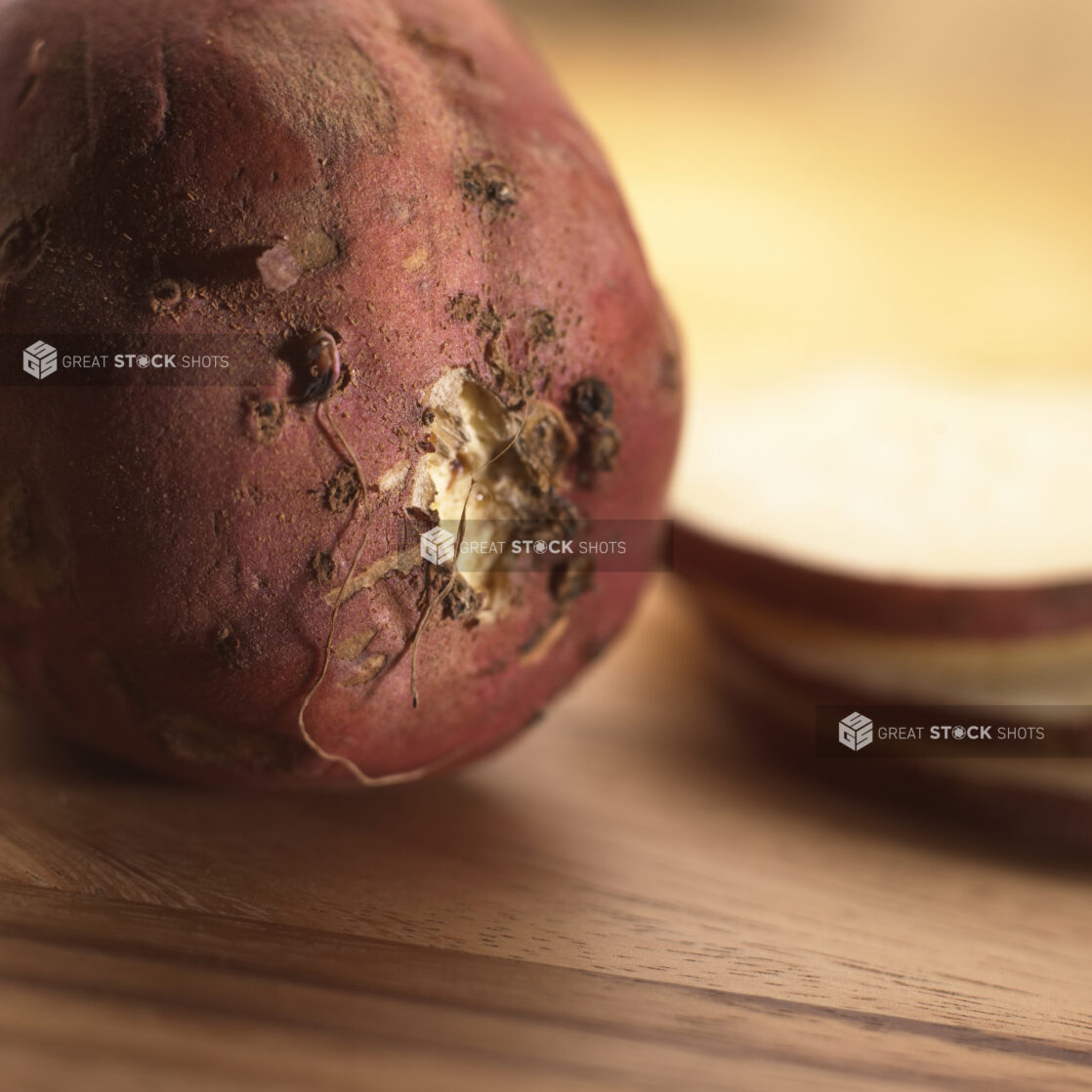 Close Up Shot of the Bottom of an Oriental Sweet Yam and Slices on a Wood Board