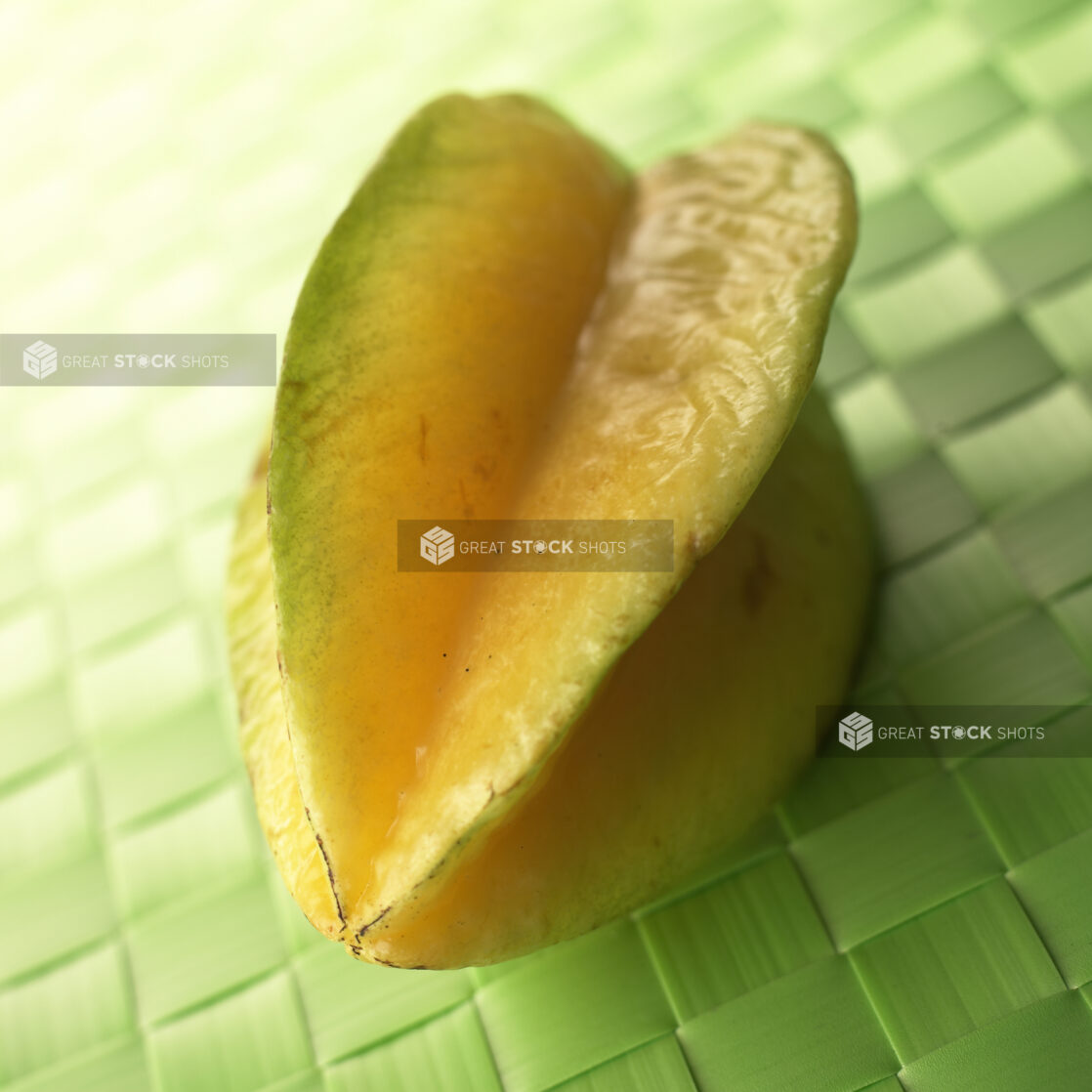 Close Up of a Whole Star Fruit on a Green Placemat