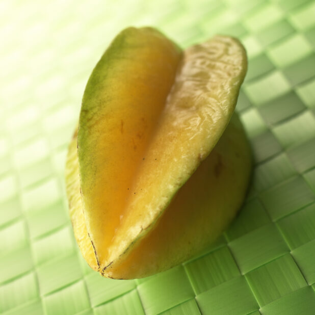 Close Up of a Whole Star Fruit on a Green Placemat