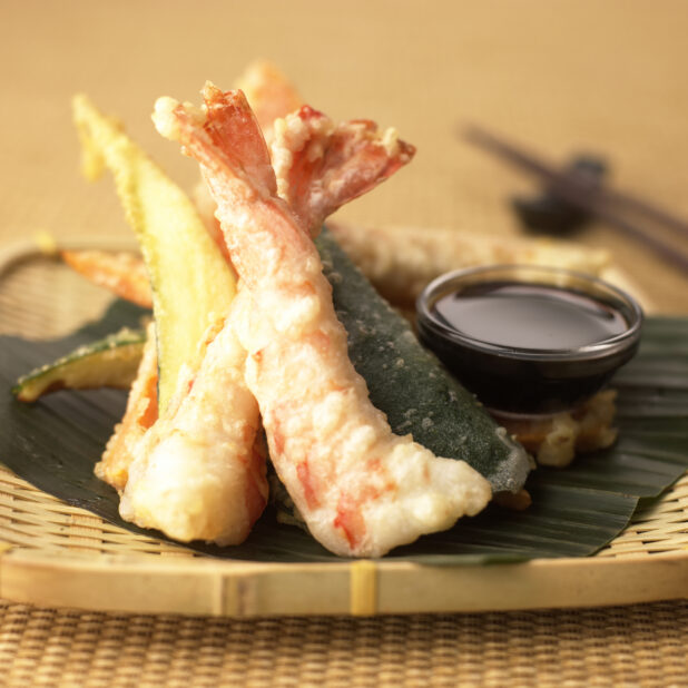 Close Up of a Bamboo Platter with Assorted Shrimp and Vegetable Tempura and a Side of Sauce