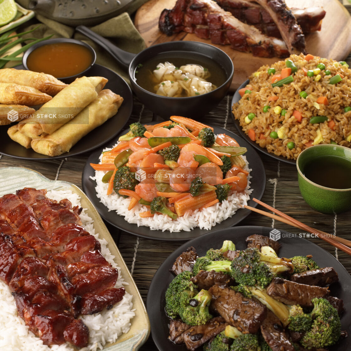 A Group Shot of Popular Chinese Take Out Dishes: BBQ Pork, Beef and Broccoli, Shrimp and Vegetable Stir Fry, Spring Rolls and Fried Rice