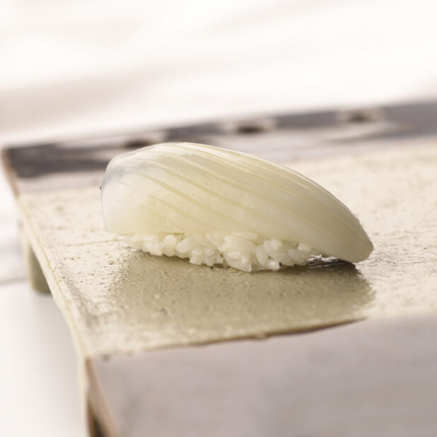 Close Up of a Ika/Squid Nigiri Sushi on a Ceramic Dish