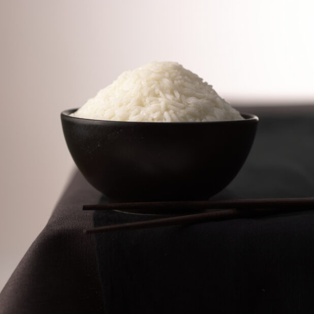Close Up of a Black Ceramic Bowl of Steamed White Chinese Long Grain Rice