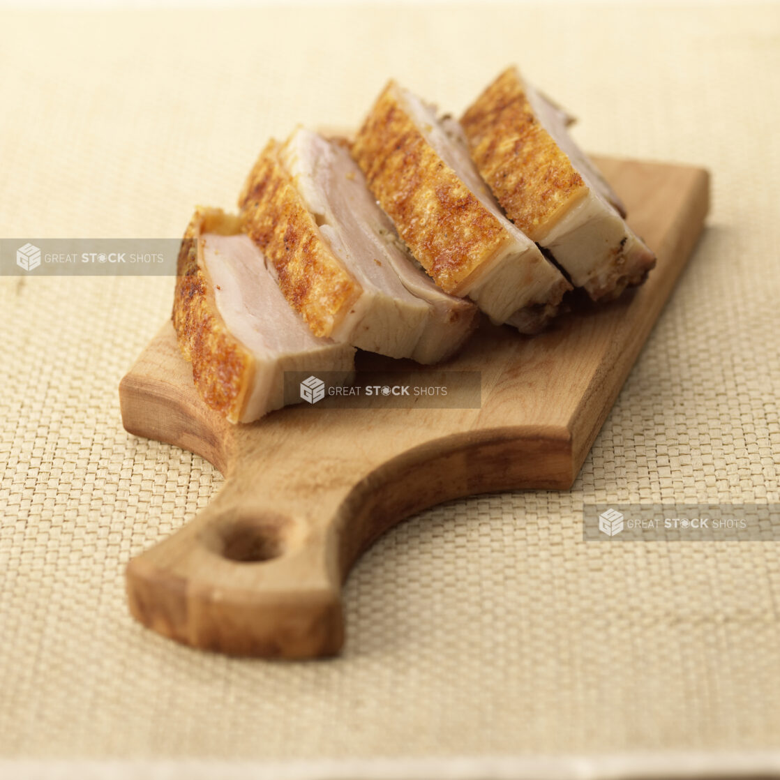 Close Up of Slices of Siu Yuk - Cantonese-Style Crispy Pork Belly - on a Wooden Platter