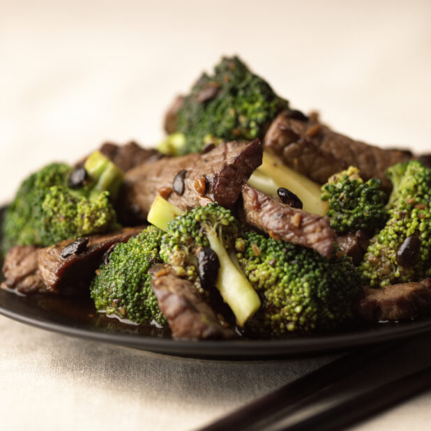 Close Up of a Dish of Beef and Broccoli Stir Fry with Black Bean Sauce on a Black Ceramic Plate