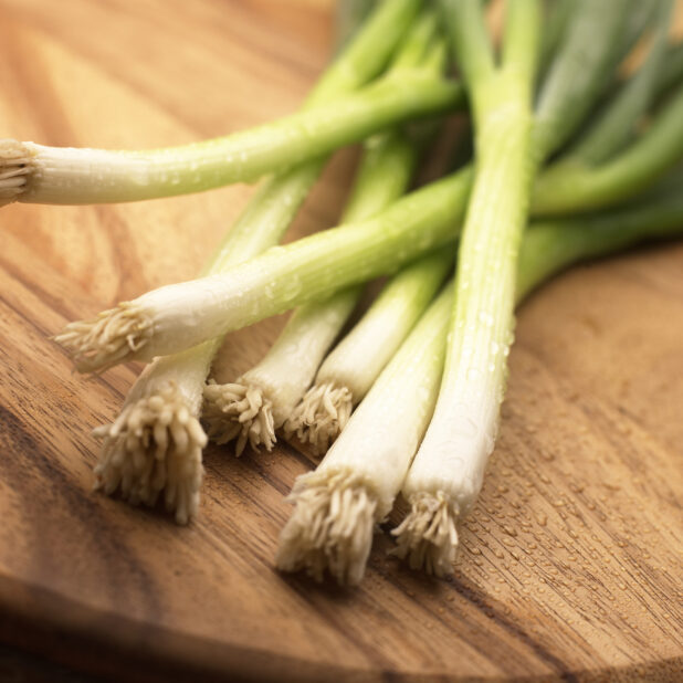 Close Up Shot of the Root Ends of Wild Leek Vegetables on a Wood Board