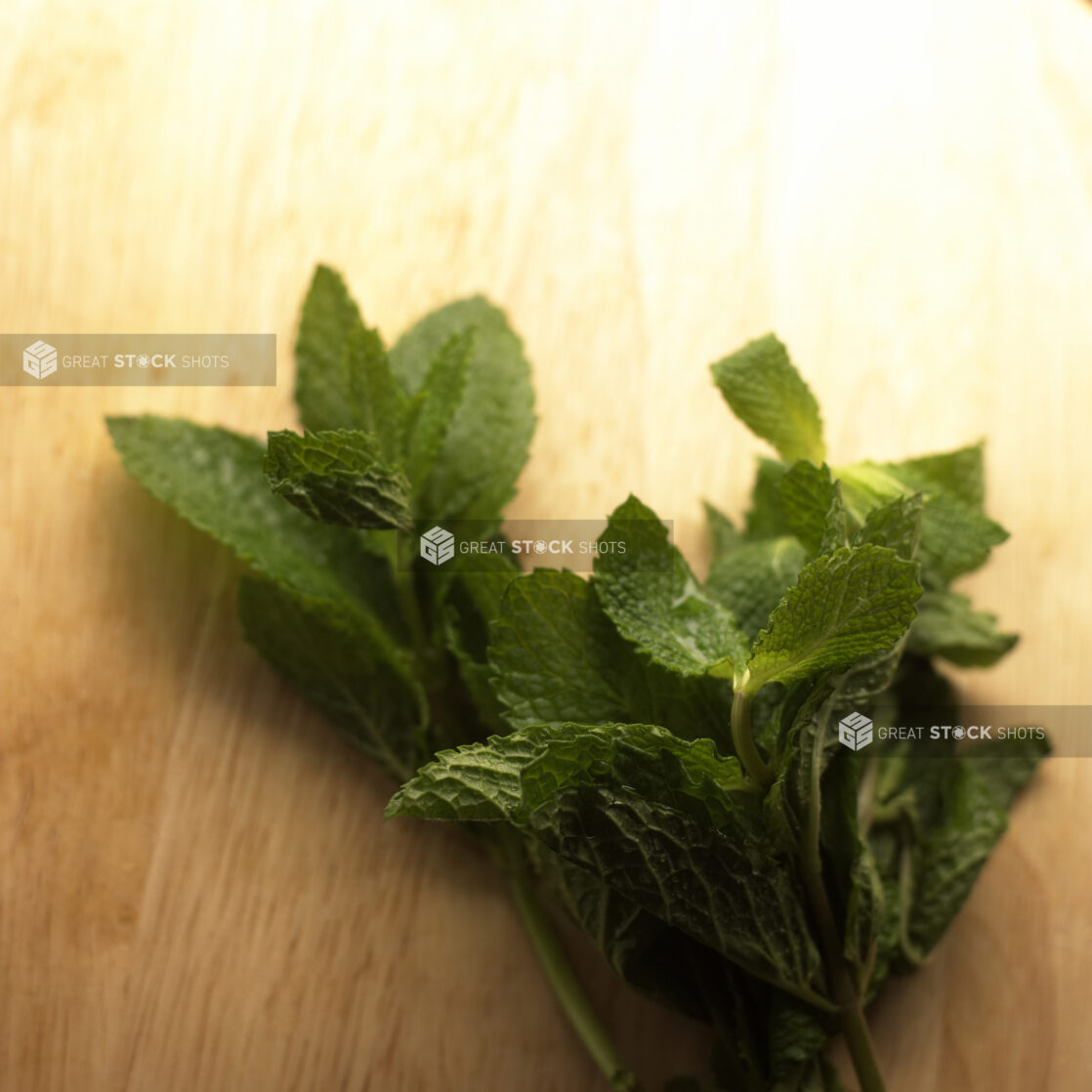 Close Up Shot of a Bunch of Fresh Peppermint Leaves on a Wooden Board