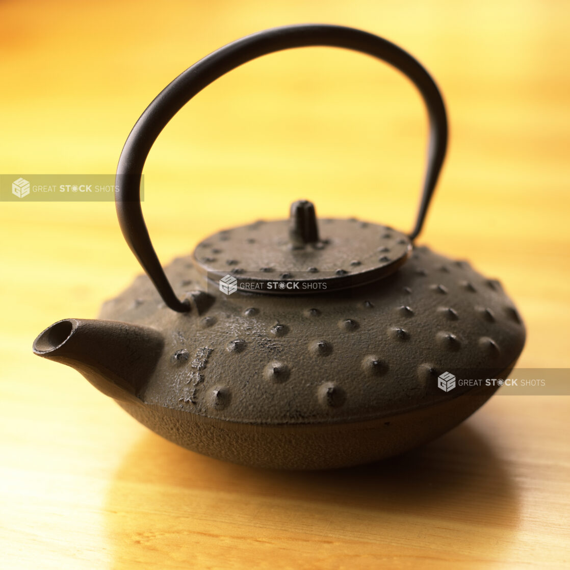 Close Up of a Japanese Cast Iron Tea Pot - Testubin - on a Wooden Table