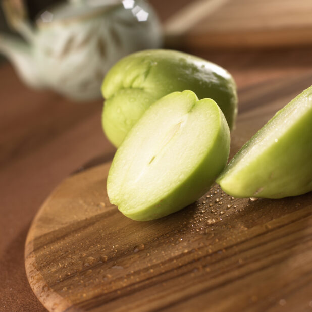 Close Up Sliced Chayote Gourd on a Wooden Board