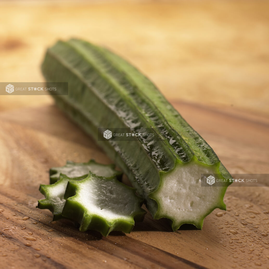 Close Up Shot of a Ridge Gourd or Chinese Okra With Some Sliced Pieces on a Wooden Board