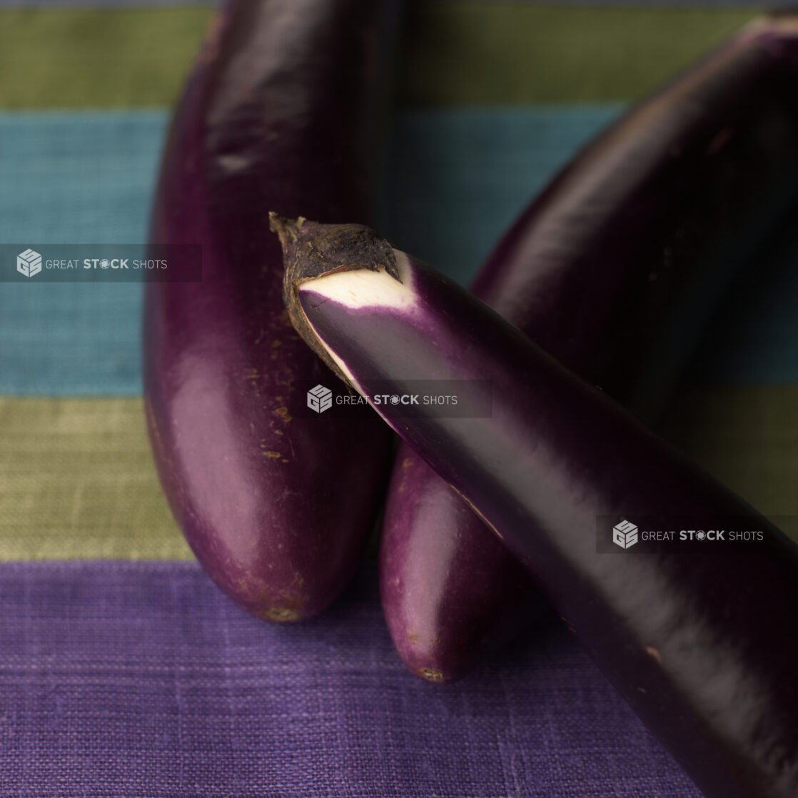 Close Up of Long Purple Eggplants or Aubergine on a Tablecloth Surface