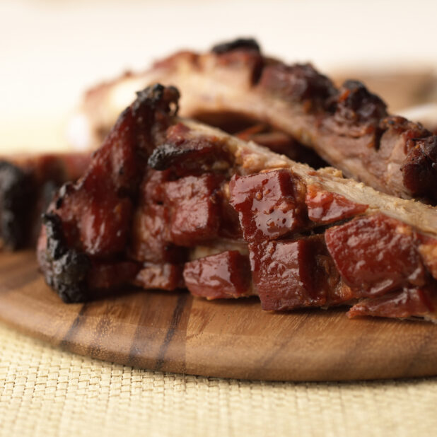 Close-Up of a Wooden Platter of Honey-Glazed BBQ Pork Ribs