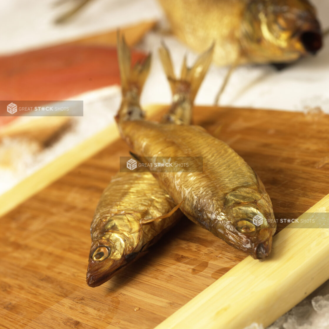 Close Up of Whole Smoked Herring Fish on a Cutting Board in an Indoor Kitchen Setting