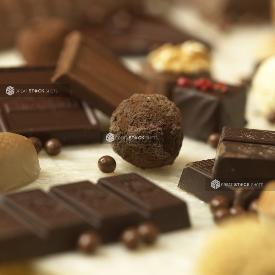 Close Up of a Chocolate Truffle Ball Surrounded by Other Chocolates in an Indoor Setting