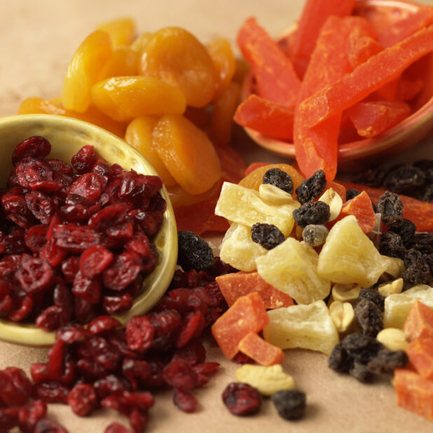 Close Up of Assorted Dried and Candied Fruits - Cranberries, Raisins, Pineapples, Papaya, Apricots - in an Indoor Setting