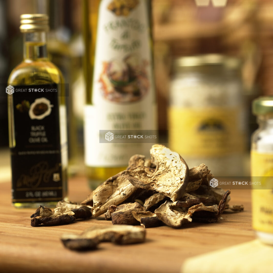 Dried Porcini Mushroom Slices on a Wooden Cutting Board with Assorted Gourmet Oils in an Indoor Setting