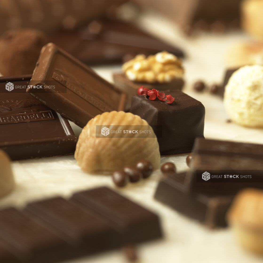 Close Up of a Belgian Chocolate Seashell, Ghirardelli Chocolate Squares and a Chocolate Truffle in an Indoor Setting