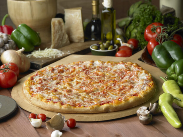 A Whole Cheese Pizza on a Wooden Pizza Peel on a Wooden Table in a Kitchen Setting