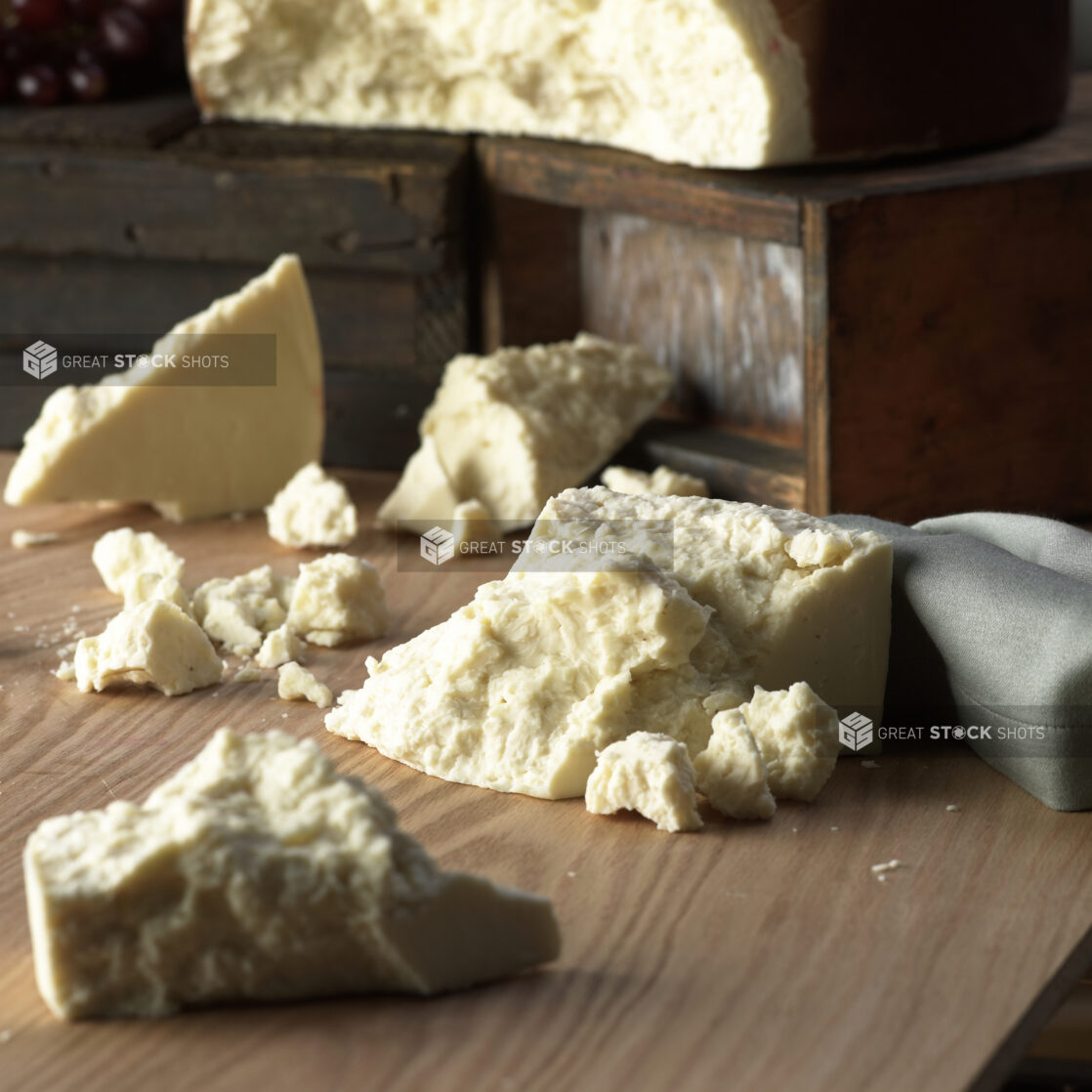 Blocks and Pieces of Fresh Feta Cheese on a Wooden Table in an Indoor Setting