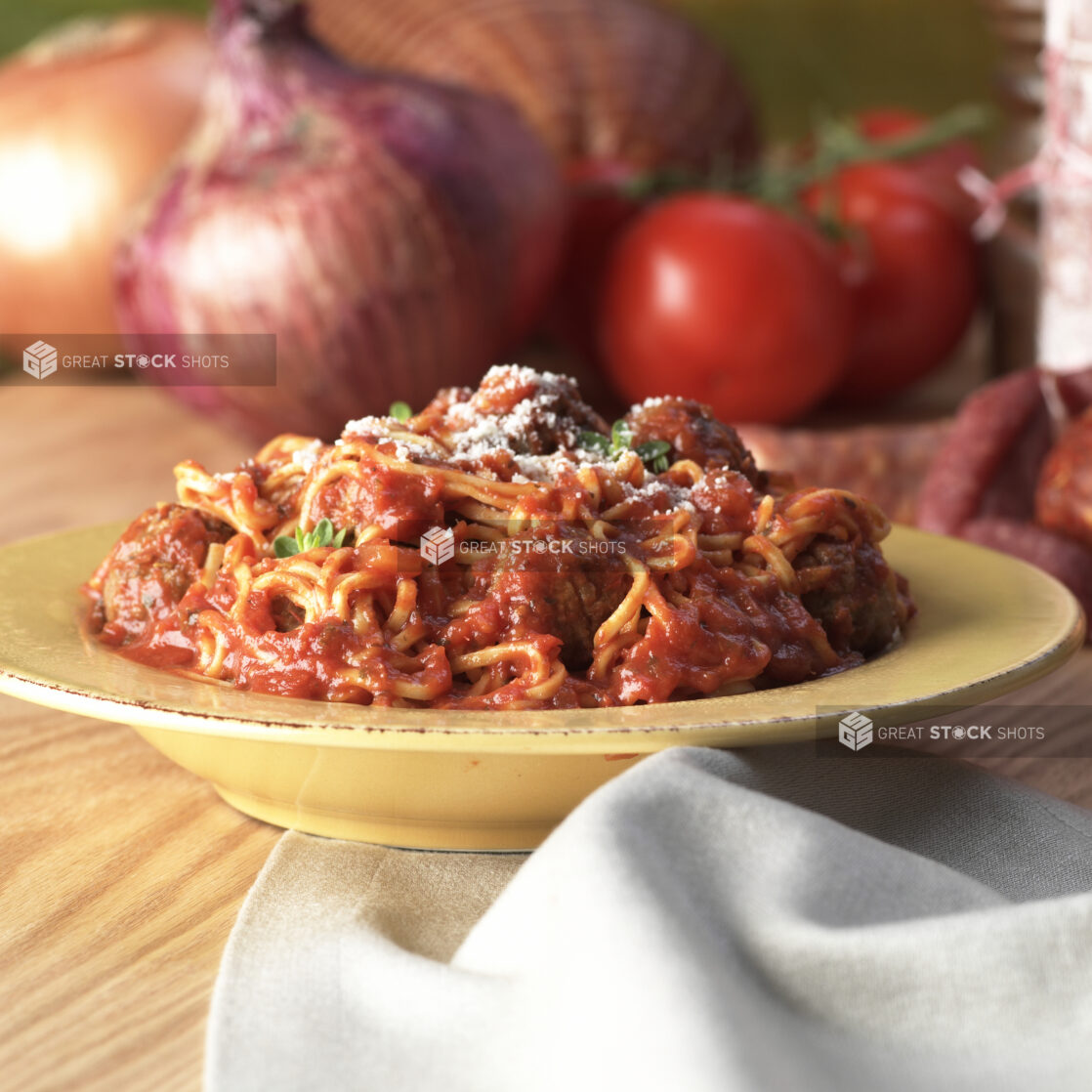 Spaghetti and Meatballs in Marinara Sauce in a Yellow Ceramic Bowl on a Wooden Table